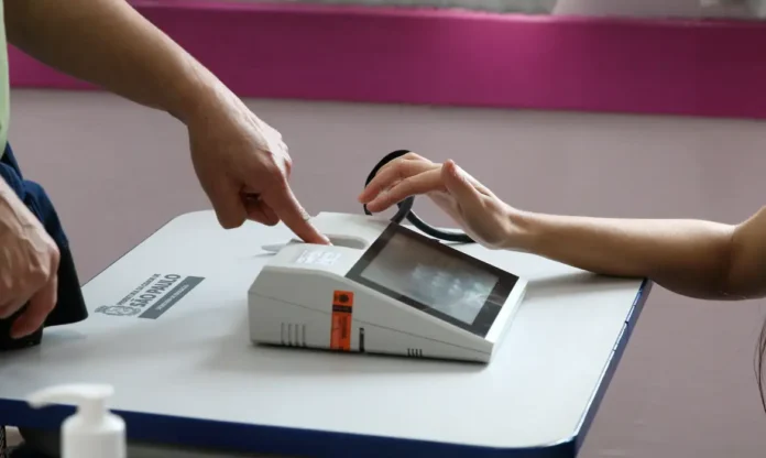 Urna eletrônica com leitor biométrico em seção eleitoral no Brasil